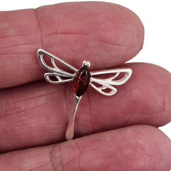 Amber Dragonfly sterling silver pendant in my hand.  Amber Dragonfly sterling silver pendant in my hand.