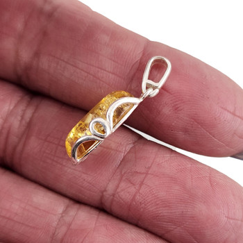 Small Citrine Amber sterling silver pendant in my hand.  Small Citrine Amber sterling silver pendant in my hand.