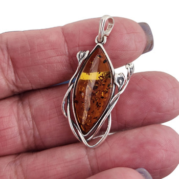Brown Amber sterling silver pendant in my hand. Brown Amber sterling silver pendant in my hand.