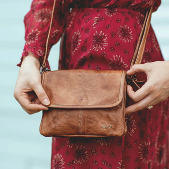 BedStu Tan Rustic Ziggy leather crossbody purse on a model. 
