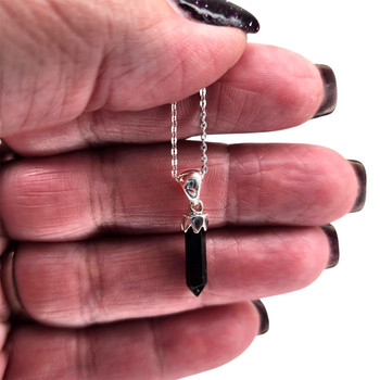 Black Onyx point pendant on a 16-18" chain in my hand.  Black Onyx point pendant on a 16-18" chain in my hand.