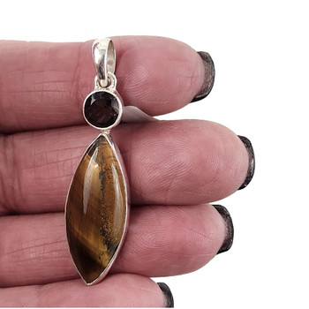Tigers Eye and Smoky Quartz sterling silver pendant in my hand. 