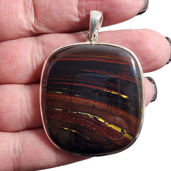 Large Red Tigers Eye sterling silver pendant in my hand. 