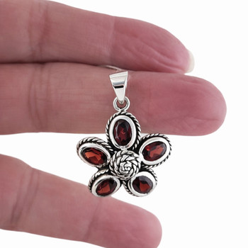 Garnet flower sterling silver pendant in my hand. 