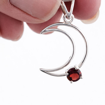 Sterling silver crescent moon with Garnet faceted stone in my hand. 