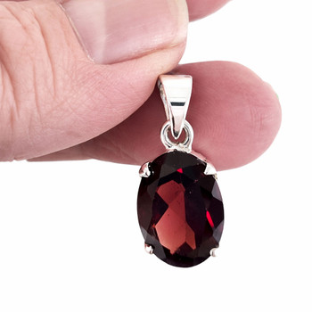 Red Garnet oval sterling silver pendant in my hand. 