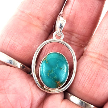 Oval Turquoise double framed sterling silver pendant in my hand. 