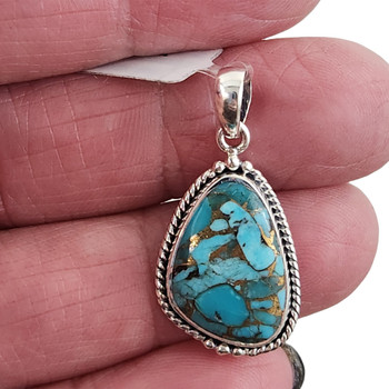 Blue Turquoise and Copper sterling silver pendant in my hand. 
