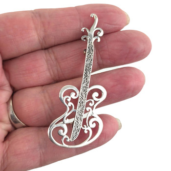 Sterling silver 2" guitar pendant in my hand. 