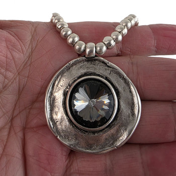 Large round gray crystal pendant on a ball-beaded chain in my hand. 