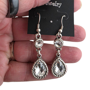 Two clear crystal dangle earrings in my hand. 