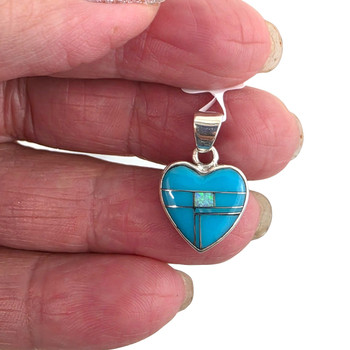 Small heart Turquoise and Opal sterling silver pendant in my hand. 