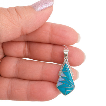 Sterling Silver kite-shaped pendant with Kingman Turquoise and Opal geometric inlay handcrafted in New Mexico, USA, in my hand.