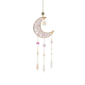 Benjamin International Rose Quartz Crescent Moon Suncatcher featuring a gold-tone crescent moon embellished with soft pink rose quartz stones, decorative sunburst accents, a suspended translucent bead, and three dangling chains with colorful iridescent crystal prisms. This 21-inch celestial hanging decoration adds a beautiful, romantic, bohemian touch to windows and home decor.