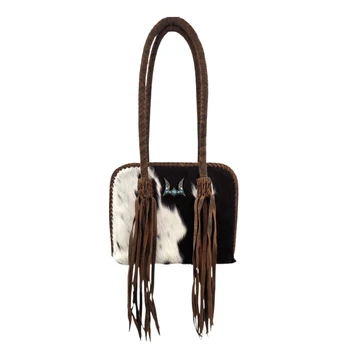 Loyal West genuine hair-on cowhide shoulder bag featuring black and white natural cowhide, long brown leather fringe tassels, braided handles, and silver-tone turquoise-colored accent.