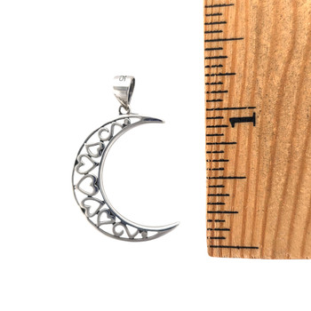 Sterling silver crescent moon with little hearts inside, with a ruler. 
