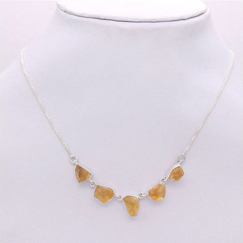 Raw Citrine silver necklace on white neck. Raw Citrine silver necklace on white neck.