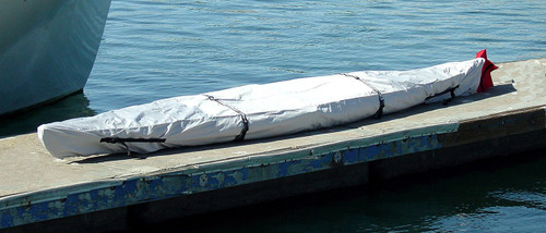 Buddy kayak cover with red warning flag bag at back of cover.