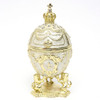 Mini Romanov White Jubilee Egg Box. The style of Peter Carl Faberge is invoked by this handsome and affordable hand enameled egg box, topped with a crown and supported by three lions with outstretched paws. The box opens from the top and can hide small jewelry or can be used as a presentation box for small gifts. Decorated with glistening Austrian crystals and gold plated.