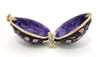 Purple Roses Floral Box. Delicate purple/white roses intertwined with green leaf tendrils on a hand enameled purple background. This egg box evokes the style of Peter Carl Faberge, court jeweler to the Russian Tsars. The enamel is baked onto a pewter base, then polished and finally set with genuine Austrian crystals. The egg is hinged and can store small jewelry. Comes in a satin-lined gift box.