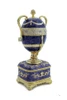 Faberge Serpent Clock Egg. A royal purple replica enamel egg of the original blue enamel egg, which was presented by Nicholas II to his mother, Maria Feodorovna, on Easter day, 1895. It features a "cercles tournants" (revolving dial) urn clock in the Louis XVI style with a snake to indicate the time. Currently, the original is owned by Prince Albert II, Prince Rainier III's son, and held in Monaco. 5¾" in height, 2" square base, slightly over 1 pound. Top half removes completely.
