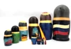 Yeltsin with Leaders (Ельцин с Вождями). The whole line of succession, from Yeltsin down to the beginning of the monarchy, is depicted in this 10 piece set. Larger dolls with more than 5 pieces are less common due to the cost of production.  A solemn Boris Yeltsin, the first post-Communist leader, heads off the caravan. A banner proclaims "Россия" (Russia) in red letter and the white, blue and red flag is painted on the back. Gorbachev in his characteristic blue suit has a yellow sash with the word Перестройка (Perestroika). His birthmark has the letters CCCP added. More leaders follow: 10 in all!