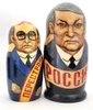 Yeltsin with Leaders (Ельцин с Вождями). The whole line of succession, from Yeltsin down to the beginning of the monarchy, is depicted in this 10 piece set. Larger dolls with more than 5 pieces are less common due to the cost of production.  A solemn Boris Yeltsin, the first post-Communist leader, heads off the caravan. A banner proclaims "Россия" (Russia) in red letter and the white, blue and red flag is painted on the back. Gorbachev in his characteristic blue suit has a yellow sash with the word Перестройка (Perestroika). His birthmark has the letters CCCP added. More leaders follow: 10 in all!