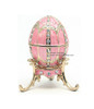 Mini Royal Pink Enamel Egg and Pendant. The style of Peter Carl Faberge is invoked by this elegant hand enameled egg box. The enamel is baked onto a pewter base, then polished and set with genuine Austrian crystals. The egg is hinged and opens to store small jewelry. Comes with its own matching color stand and a matching egg pendant (not shown in picture) with a 19" gold tone chain. Housed in a satin-lined gift box.
