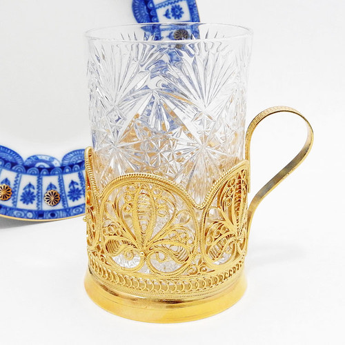 "Anna" Gold Plated Teaglass Holder.  Handmade delicate filigree podstakannik (подстаканник) was made in the village of Kazakovo. High quality filigree is reminiscent of lace work popularly known as "bobbin lace." 24Kt gold plate over copper. Comes with a Russian crystal glass. About 5" in height.
