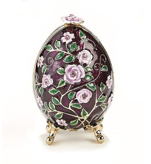 Purple Roses Floral Box. Delicate purple/white roses intertwined with green leaf tendrils on a hand enameled purple background. This egg box evokes the style of Peter Carl Faberge, court jeweler to the Russian Tsars. The enamel is baked onto a pewter base, then polished and finally set with genuine Austrian crystals. The egg is hinged and can store small jewelry. Comes in a satin-lined gift box.