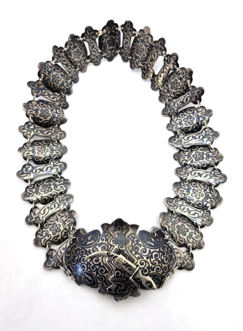 Russian 84 Silver Engraved Niello from Caucasus, early 20th c. Russian empire hallmarks indicating Kiev throughout. Hand forged with intricate chased engraved designs. Large buckle is latched by a clasp in the form of a miniature dagger on a chain. All parts are marked 84 for silver purity assay and maker's identification mark [LK]. 7oz (198 grams). On the small side (for a younger waist). 26½" in length, buckle is 2½" and segments 2".