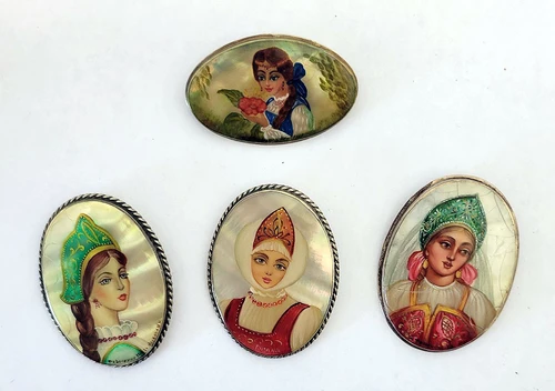 Four Fedoskino Oil Painting Portraits on Mother of Pearl. A nice opportunity to pick up some hand painted portrait brooches. Some crazing to the lacquer that covers the mother of pearl, which doesn't detract but gives them an "antique" look. Faces are all near fine, and all findings are in working order.