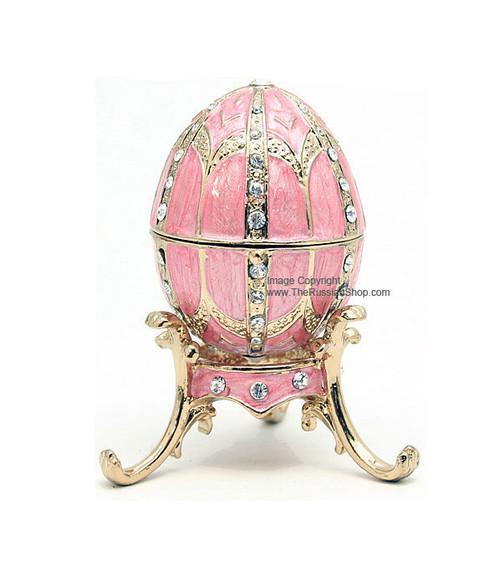Mini Royal Pink Enamel Egg and Pendant. The style of Peter Carl Faberge is invoked by this elegant hand enameled egg box. The enamel is baked onto a pewter base, then polished and set with genuine Austrian crystals. The egg is hinged and opens to store small jewelry. Comes with its own matching color stand and a matching egg pendant (not shown in picture) with a 19" gold tone chain. Housed in a satin-lined gift box.