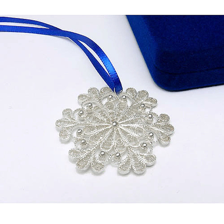 Snowflake (Снежинка) Ornament. An exquisite Christmas ornament "spun" by hand in the village of Kazakovo. The original design was created by master artist Antonina Varlova, to evoke the charm and beauty of a delicate snowflake. Pure silver over copper.