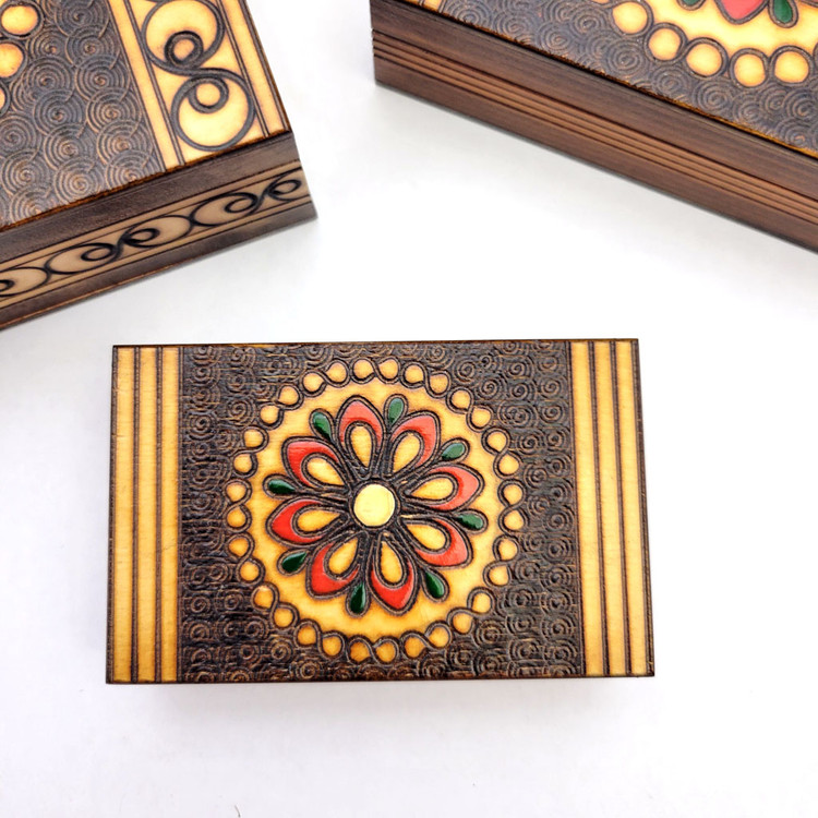 Set of 5 nested wooden Polish boxes. Crafted in Zakopane (Podhale region), a town which lies at the foothills of the Tatra Mountains. Each box is identically carved and stained with decorations incised using the techniques of the craft of traditional pyrography (woodburning). Boxes are lined with bright red felt (a nice touch), and nest perfectly within one another. The center of each box is a spiral flower with red and green enhancements and the surrounding wood is intricately textured. Three largest boxes have elaborate edge borders. An unusual set in brand new condition.