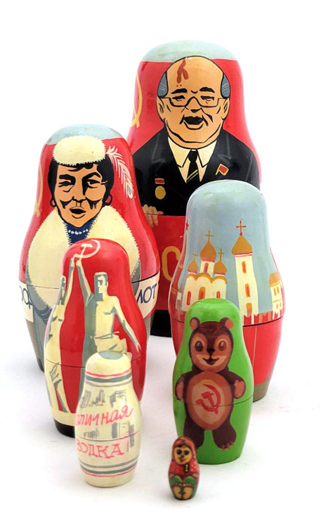 Gorbachev and Soviet Promo Matryoshka Doll. One of the more unusual, or perhaps original, Gorby dolls we've ever seen. It starts off in typical fashion with Mikhail Gorbachev in a brown suit with flag pin and medal standing against a large red banner with the word Перестройка (Perestroika, i.e, Reform Movement), and behind him another banner with a yellow hammer and sickle and star. After him, and keeping with the red banner theme, comes an indigenous woman in fur with the word Аэрофлот (Aeroflot, the, at the time, Soviet Airlines) in front of an airplane and more hammers, sickles and stars. The third piece is the Kremlin and its towers. Next is the Soviet statue of a pair holding a hammer and sickle: "Worker and Kolkhoz Woman", created for the 1937 World's Fair in Paris by Vera Mukhina. On the back is CCCP and a star. The next piece is a smiling bear cub with a hammer and sickle on its belly and more CCCP and a star. Nexxt to last is a representation of a Stolichnaya Vodka label and "Made in USSR" in English. The last piece is a tiny matryoshka girl. The doll is actually signed in Russian by the artist, but not dated. We estimate that it was painted pre-1991, perhaps 1988-1990, a souvenir representation of Soviet symbols and goods. Gorbachev and Soviet Promo Matryoshka Doll. One of the more unusual, or perhaps original, Gorby dolls we've ever seen. It starts off in typical fashion with Mikhail Gorbachev in a brown suit with flag pin and medal standing against a large red banner with the word Перестройка (Perestroika, i.e, Reform Movement), and behind him another banner with a yellow hammer and sickle and star. After him, and keeping with the red banner theme, comes an indigenous woman in fur with the word Аэрофлот (Aeroflot, the, at the time, Soviet Airlines) in front of an airplane and more hammers, sickles and stars. The third piece is the Kremlin and its towers. Next is the Soviet statue of a pair holding a hammer and sickle: "Worker and Kolkhoz Woman", created for the 1937 World's Fair in Paris by Vera Mukhina. On the back is CCCP and a star. The next piece is a smiling bear cub with a hammer and sickle on its belly and more CCCP and a star. Nexxt to last is a representation of a Stolichnaya Vodka label and "Made in USSR" in English. The last piece is a tiny matryoshka girl. The doll is actually signed in Russian by the artist, but not dated. We estimate that it was painted pre-1991, perhaps 1988-1990, a souvenir representation of Soviet symbols and goods.