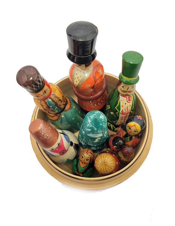 Matryona (Матрена). The name of this unusual setmeans "lady". This type of doll, from Sergiev Posad, was made about 25 years ago. It is of the toy "villagers" type, which when opened, reveal a number of small carved and painted pieces. This one has two men and a woman, a snowman and a Christmas tree, and five smaller pieces, including a penguin. Doll is about 8½" in height with pieces between 4" down to 1".The head doll is nicely decorated with a scene of children riding a sled down a hill. Their village home is in the background. This versatile doll can also be a "counting" toy for slightly older children (over 3) and a Christmas set.