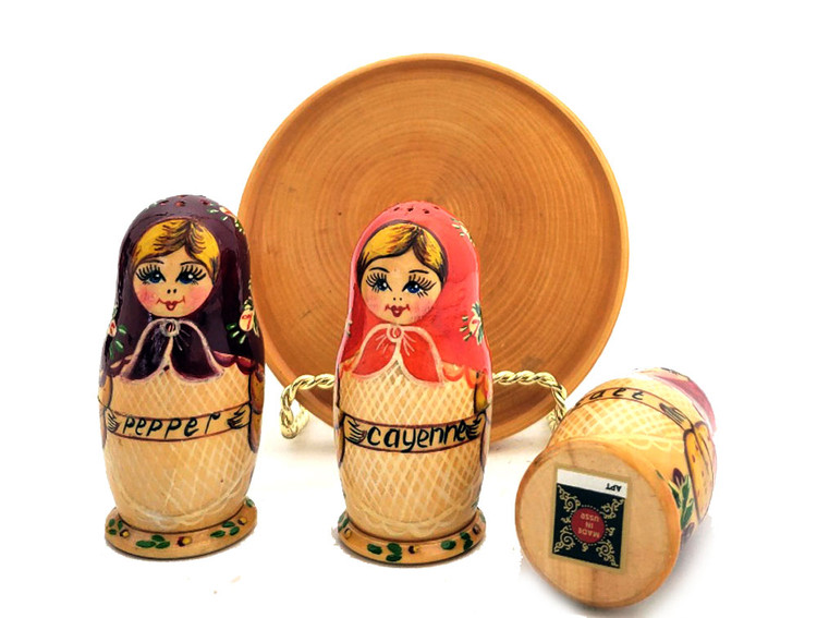 Matryoshka Seasoning Trio. An adorable set of maidens from Sergiev Posad, probably 1990 or a bit earlier. Each matryoshka opens to house either salt, papper, or cayenne (?). Titles in English indicating was made for an export market. Tray seems to have been added later. All wood, and all hand decoration. Both decorative and functional.  Dolls just under 3¼" in height, tray just under 4¼" in diameter.