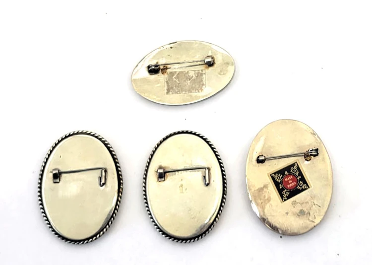 Four Fedoskino Oil Painting Portraits on Mother of Pearl. A nice opportunity to pick up some hand painted portrait brooches. Some crazing to the lacquer that covers the mother of pearl, which doesn't detract but gives them an "antique" look. Faces are all near fine, and all findings are in working order.