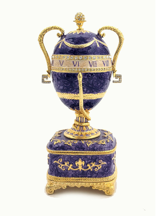 Faberge Serpent Clock Egg. A royal purple replica enamel egg of the original blue enamel egg, which was presented by Nicholas II to his mother, Maria Feodorovna, on Easter day, 1895. It features a "cercles tournants" (revolving dial) urn clock in the Louis XVI style with a snake to indicate the time. Currently, the original is owned by Prince Albert II, Prince Rainier III's son, and held in Monaco. 5¾" in height, 2" square base, slightly over 1 pound. Top half removes completely.