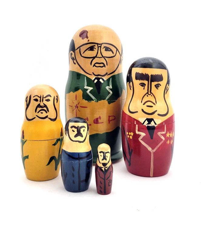 Gorbachev with Old Communist Leaders. This set appears to be an early one in the lineage of Gorbachev, aka, political nesting dolls. The anonymous artist has tackled his or her representation of the former Soviet leaders by simplifying and caricaturing them. The approach is somewhat demure, and the choice of colors is unusual. Mikhail Gorbachev is wearing a green suit with a large map of the USSR in yellow. Leonid Brezhnev wears a brown suit with stars and ribbons signifying his importance. Khrushchev is in Ukrainian peasant yellow covered by green corn stalks  Stalin is in blue and Lenin in dark brown. Most of the the early "Gorby" (an mildly affectionate name for "Gorbachev") dolls were made by talented amateurs in the Soviet Union. Mikhail Gorbachev transformed the USSR by unleashing a pair of political, and cultural, waves. The first was "Гласность" (Glasnost, i.e, openness) and "Перестройка" (Perestroika, i.e., rebuilding). These shock waves led to unrestrained freedom of expression. This set leading off with Gorbachev indicates that it was made before 1991, before Yeltsin was elected, and Gorbachev demoted to second place.