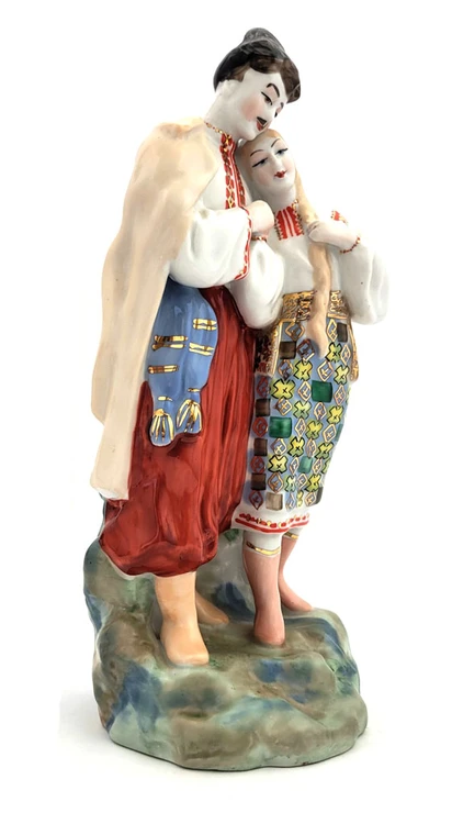 May Night (Майская ночь). A romantic moment is depicted as Levko, the young Cossack, puts his arm around his beloved Hanna (Ganna) as she, in turn, lays her head upon his shoulder. Scene from the otherwise quite spooky short story "May Night" from Nikolai Gogol's "Evenings on a Farm Near Dikanka", that was made into an opera by Nikolai Rimsky-Korsakov. Original design by Ukrainian sculptor and ceramicist Oksana Leontievna Zhnikrup (the wife of Vladislav Ivanovich Shcherbina). Porcelain, polychrome overglaze. 11¼"x4⅝"x4¼".