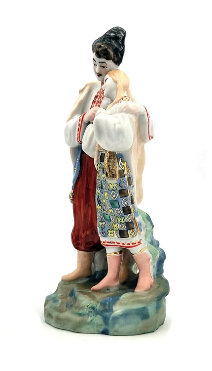 May Night (Майская ночь). A romantic moment is depicted as Levko, the young Cossack, puts his arm around his beloved Hanna (Ganna) as she, in turn, lays her head upon his shoulder. Scene from the otherwise quite spooky short story "May Night" from Nikolai Gogol's "Evenings on a Farm Near Dikanka", that was made into an opera by Nikolai Rimsky-Korsakov. Original design by Ukrainian sculptor and ceramicist Oksana Leontievna Zhnikrup (the wife of Vladislav Ivanovich Shcherbina). Porcelain, polychrome overglaze. 11¼"x4⅝"x4¼".