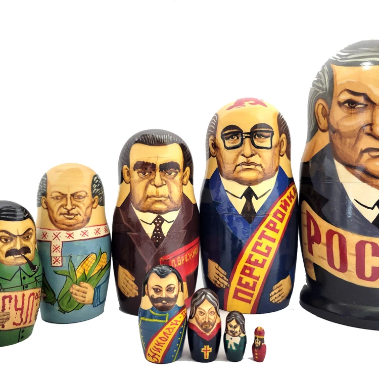 Yeltsin with Leaders (Ельцин с Вождями). The whole line of succession, from Yeltsin down to the beginning of the monarchy, is depicted in this 10 piece set. Larger dolls with more than 5 pieces are less common due to the cost of production.  A solemn Boris Yeltsin, the first post-Communist leader, heads off the caravan. A banner proclaims "Россия" (Russia) in red letter and the white, blue and red flag is painted on the back. Gorbachev in his characteristic blue suit has a yellow sash with the word Перестройка (Perestroika). His birthmark has the letters CCCP added. More leaders follow: 10 in all!