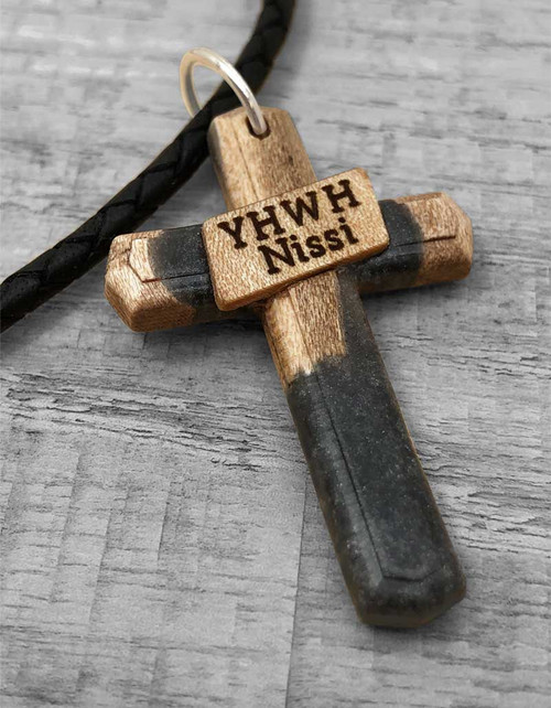 YHWH Nissi Maple Wood pendant displayed on gray wood.
