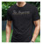 Young man modeling his new black Christian tee — "The Nazarene" with John 1:3 Bible verse.