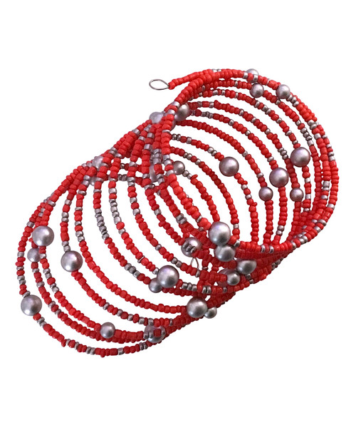 Pulsera en espiral con piedras de color coral y perlas plateadas.