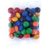 A clear plastic bag filled with colourful round candies in red, yellow, green, blue, orange, and black.