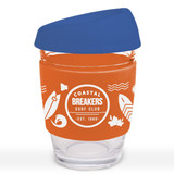 A reusable coffee cup with a blue silicone lid and an orange sleeve featuring a design related to surfing.