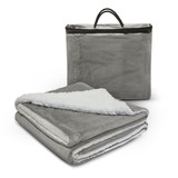 A grey luxury blanket with a soft white underside, folded and placed next to a zipped storage bag.